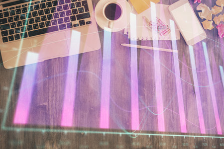 Financial market graph and top view computer on the desktop background. Double exposure. Investment concept.の写真素材