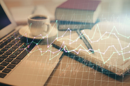 Double exposure of financial chart drawing and desktop with coffee and items on table background. Concept of forex market tradingの写真素材