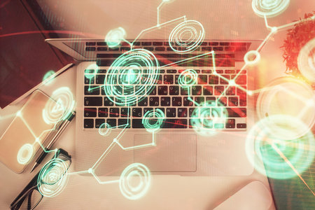 Social network hologram drawings over computer on the desktop background. Top view. Double exposure.の写真素材
