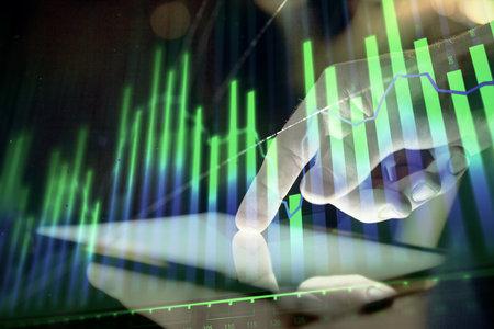 Double exposure of man's hands holding and using a digital device and forex graph drawing. Financial market concept.の写真素材