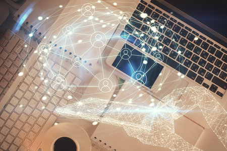 Social network hologram drawings over computer on the desktop background. Top view. Double exposure.の写真素材