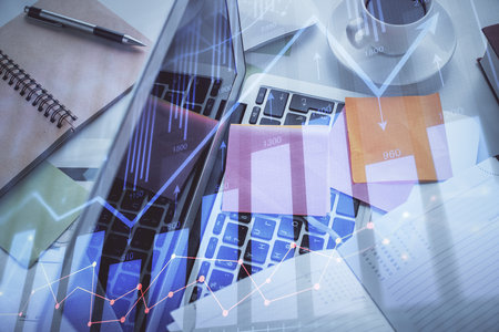 Multi exposure of financial chart drawing over table background with computer. Concept of research and analysis. Top view.の写真素材