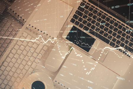 Financial market graph and top view computer on the desktop background. Multi exposure. Investment concept.の写真素材
