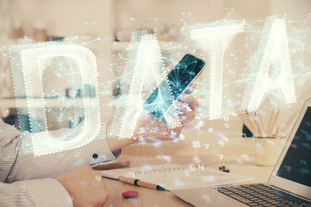 Double exposure of man's hand holding and using a digital device and data theme hologram drawing. Technology concept.の写真素材