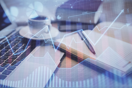 Double exposure of forex chart drawing and desktop with coffee and items on table background. Concept of financial market tradingの写真素材