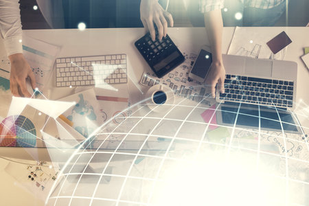Double exposure of man and woman working together and technology theme world map drawing hologram. International business tech concept. Computer background.の写真素材