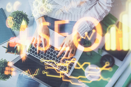 Double exposure of woman hands working on computer and SEO hologram drawing. Top View. Search...