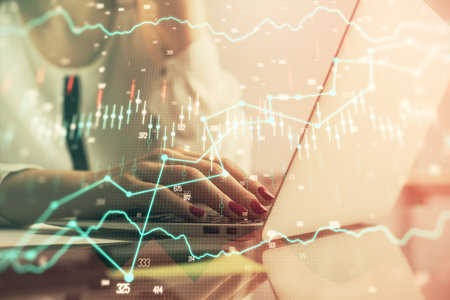 Double exposure of woman hands typing on computer and financial graph hologram drawing. Stock market analysis concept.の写真素材