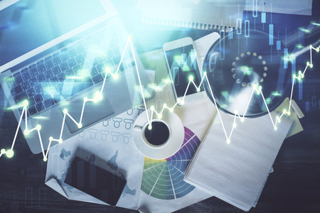 Financial market graph and top view computer on the desktop background. Double exposure. Investment...