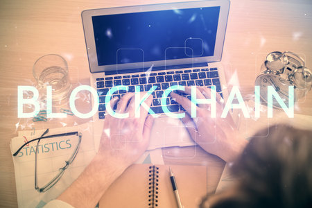 Double exposure of man's hands typing over computer keyboard and crypto currency theme hologram drawing. Top view. Blockchain concept.の写真素材