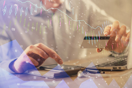 Double exposure of man hands holding a credit card and Forex graph drawing. Stock trading and...