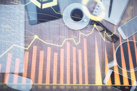 Double exposure of financial chart hologram over desktop with phone. Top view. Mobile trade platform concept.の写真素材
