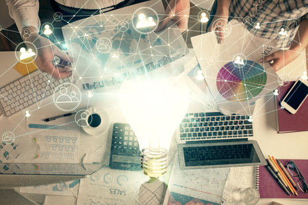 Double exposure of man and woman working together and bulb drawing. Computer background. Top View. Idea concept.の写真素材
