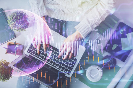 Double exposure of woman hands working on computer and forex chart hologram drawing. Top View. Financial analysis concept.の写真素材