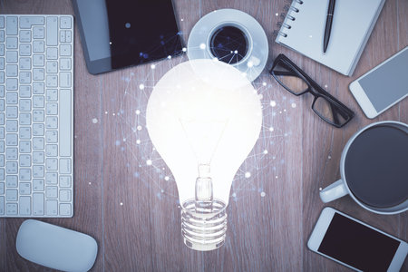 Double exposure of bulb drawing over table with phone. Top view. Concept of idea.の写真素材