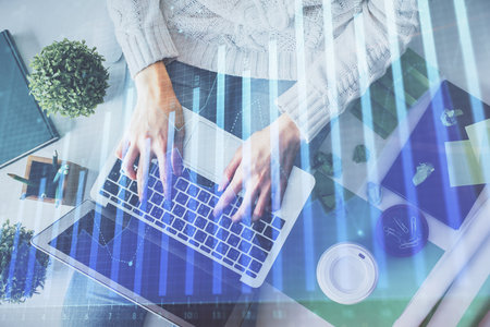 Double exposure of woman hands working on computer and forex chart hologram drawing. Top View. Financial analysis concept.の写真素材