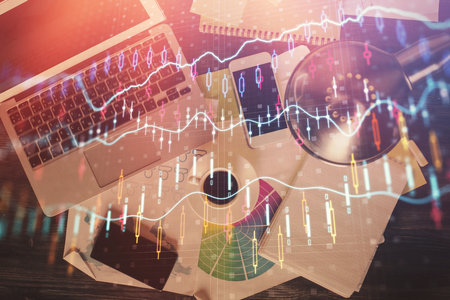 Financial market graph and top view computer on the desktop background. Multi exposure. Investment concept.の写真素材