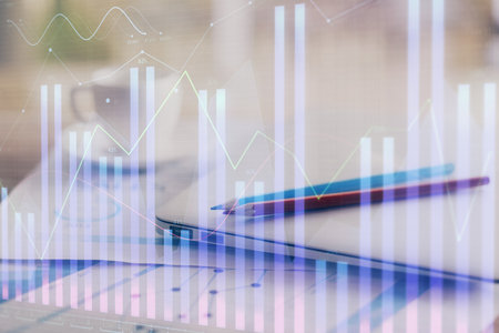 Forex graph hologram on table with computer background. Double exposure. Concept of financial markets.の写真素材