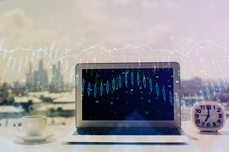 Forex graph hologram on table with computer background. Multi exposure. Concept of financial markets.の写真素材