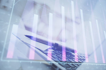 Forex graph hologram on table with computer background. Multi exposure. Concept of financial markets.の写真素材