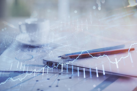 Forex graph hologram on table with computer background. Double exposure. Concept of financial markets.の写真素材