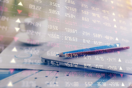 Forex graph hologram on table with computer background. Double exposure. Concept of financial markets.の写真素材