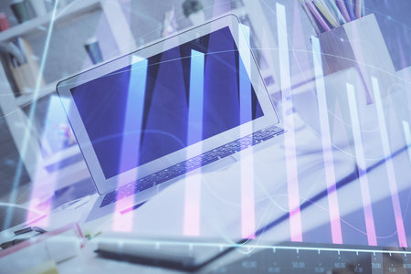 Forex graph hologram on table with computer background. Multi exposure. Concept of financial markets.の写真素材