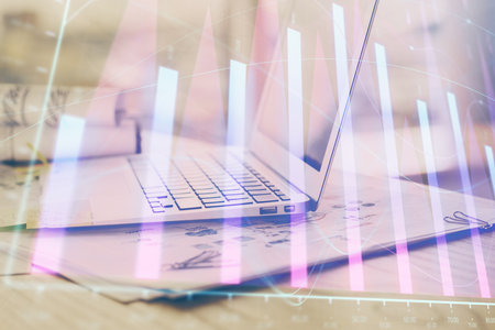 Forex graph hologram on table with computer background. Multi exposure. Concept of financial markets.の写真素材