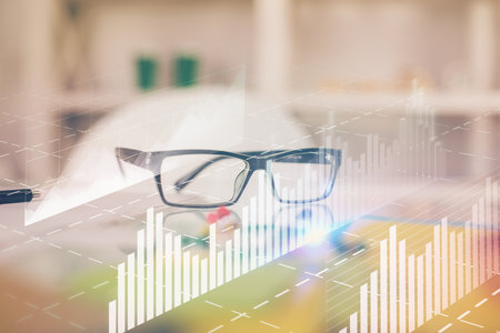Financial chart hologram with glasses on the table background. Concept of business. Double exposure.の写真素材