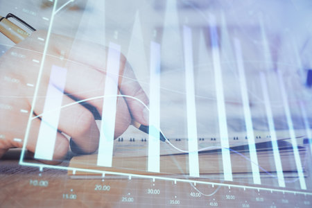 Double exposure of man doing notes of stock market with forex graph. Concept of research and trading.の写真素材