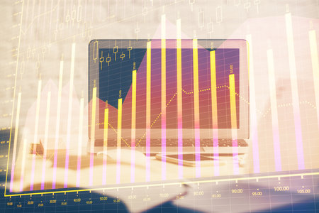 Stock market graph on background with desk and personal computer. Double exposure. Concept of financial analysis.の写真素材