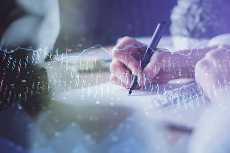 Financial forex graph displayed on hands taking notes background. Concept of research. Multi exposureの写真素材