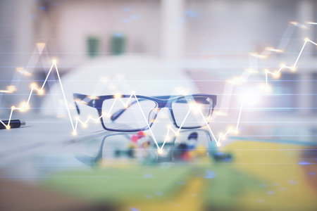 Financial graph hologram with glasses on the table background. Concept of business. Double exposure.の写真素材