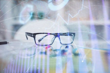 Financial graph hologram with glasses on the table background. Concept of business. Double exposure.の写真素材
