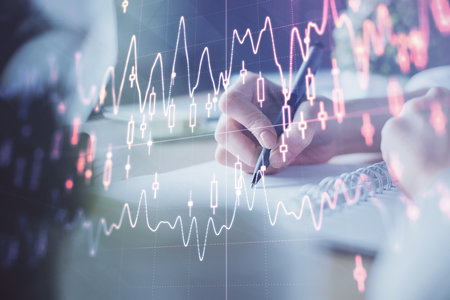 Financial forex graph displayed on hands taking notes background. Concept of research. Multi exposureの写真素材