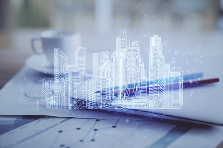 Desktop computer background in office and big town buildings hologram drawing. Double exposure. Smart city concept.の写真素材