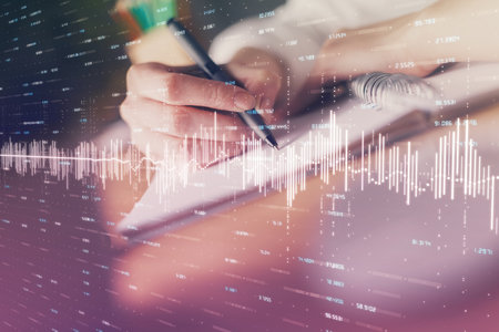 Financial forex graph displayed on hands taking notes background. Concept of research. Double exposureの写真素材