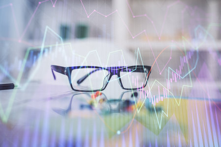 Financial chart hologram with glasses on the table background. Concept of business. Double exposure.の写真素材