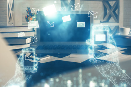 Desktop computer background in office and flying envelops hologram drawing. Multi exposure. Electronic mail concept.の写真素材