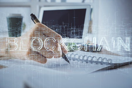 Cryptocurrency hologram, bitcoin, ico theme over hands taking notes background. Concept of...