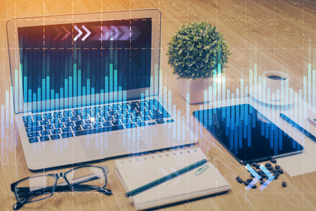 Double exposure of chart and financial info and work space with computer background. Concept of...