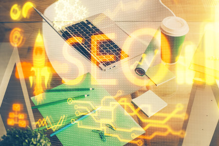 Double exposure of table with computer and seo drawing hologram. Search optimization concept.の写真素材