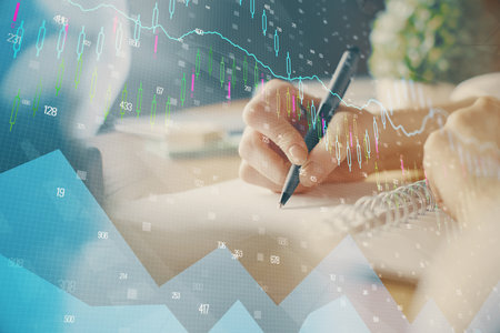 Financial forex graph displayed on hands taking notes background. Concept of research. Multi exposureの写真素材