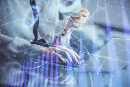 Double exposure of businesswoman hands typing on computer and financial graph hologram drawing. Stock market analysis concept.の写真素材