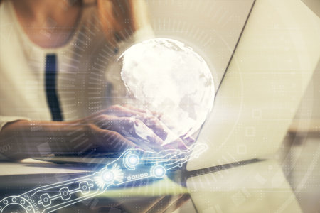 Double exposure of woman hands working on computer and world map hologram drawing. International technology business concept.の写真素材