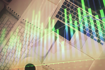 Financial market graph and top view computer on the desktop background. Multi exposure. Investment concept.の写真素材