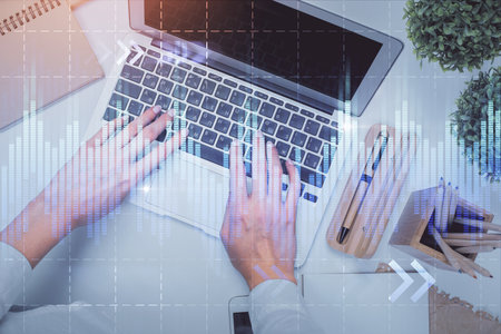Double exposure of woman hands working on computer and forex graph hologram drawing. Top View. Financial analysis concept.の写真素材