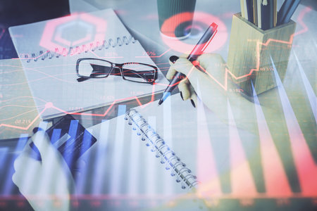 Multi exposure of woman on-line shopping holding a credit card and financial graph drawing. Stock market E-commerce concept.の写真素材