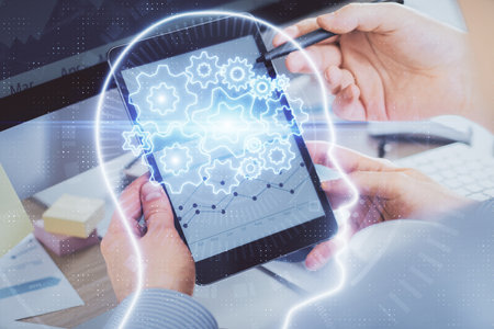 Double exposure of man's hand holding and using a digital device and brain hologram drawing. Data...