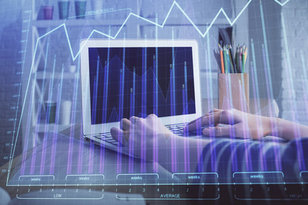 Double exposure of woman hands typing on computer and forex chart hologram drawing. Stock market invest concept.の写真素材
